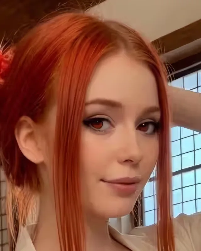 Close-up portrait of an adult AI-generated woman with red hair